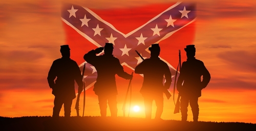 shutterstock_2147930295.jpg Silhouetted soldiers saluting against a sunset backdrop with a Confederate flag