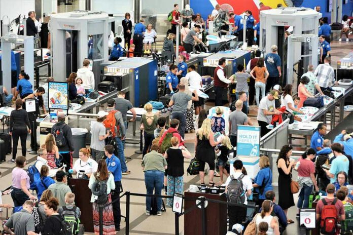 1463547893-1 Crowd at an airport security checkpoint with TSA officers.