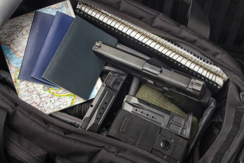 shutterstock1456619342jpg Handgun and magazines in an open travel bag