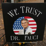 FAUCI CRONY Quits — Why The Silence? Sign reading We Trust Dr. Fauci on display.