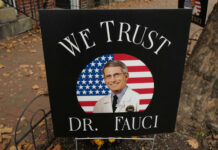 FAUCI CRONY Quits — Why The Silence? Sign reading We Trust Dr. Fauci on display.