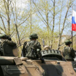 SHOCKING Nuclear Exercises Near NATO! What Now? Soldiers on an armored vehicle with a national flag