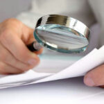 No-Body Case Hinges On One Freezer Person examining document with magnifying glass.