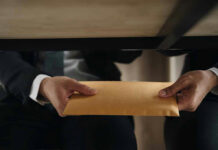 Elite Club Exposed — Spy Goldmine Unlocked Two people exchanging an envelope under a table.