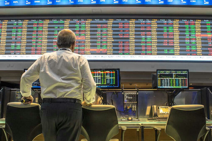 391295668-1 Person viewing stock market data on multiple screens.