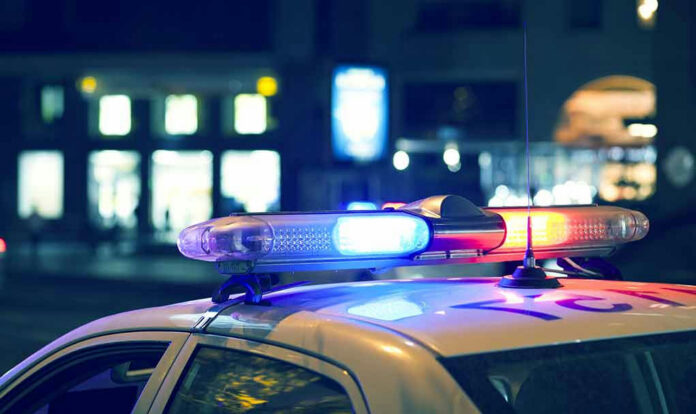 582908293 Police car with flashing lights at night.