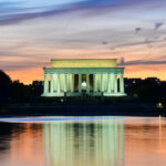 Olympian Cuffed at Lincoln Memorial Lincoln Memorial illuminated at sunset with reflection in water