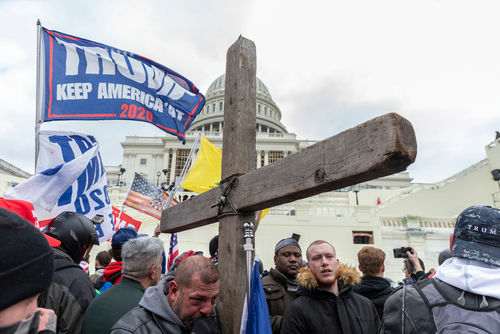 shutterstock_1889190940 Protesters with Trump flag and cross outside the Capitol building.