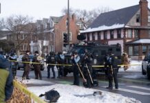 ICE Killing Sparks Million-Dollar Reward Police officers at a crime scene with a tactical vehicle in a snowy urban area
