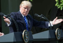 Trump’s NATO Ultimatum Lands in Ankara Man speaking at a podium, arms extended outward.