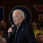 Carville Torches Biden: ‘Tragic’ Meltdown Man speaking into microphone at crowded event.