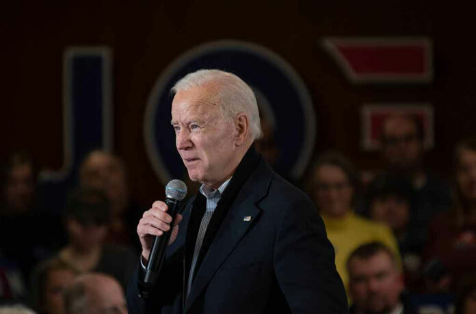 1641343303 Man speaking into microphone at crowded event.