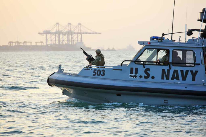 389280448 U.S. Navy patrol boat on water near industrial port.