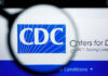 Magnifying glass over CDC logo on a website.