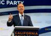 Blue MAGA Bombshell: Dems Chase Trump’s Base Man in suit speaking at a podium with microphones