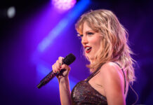 Elite Wedding Locks Down NYC Singer performing on stage with a microphone under colorful lights