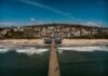 Woman Slaps Pro-Trump Teen on Boardwalk Aerial view of a pier extending into the ocean with a beach and residential area in the background