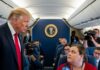 A political figure interacting with a reporter on an airplane
