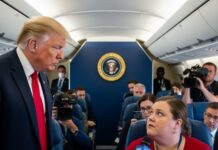 A political figure interacting with a reporter on an airplane