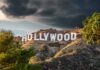 Hollywood sign on hills under cloudy sky.