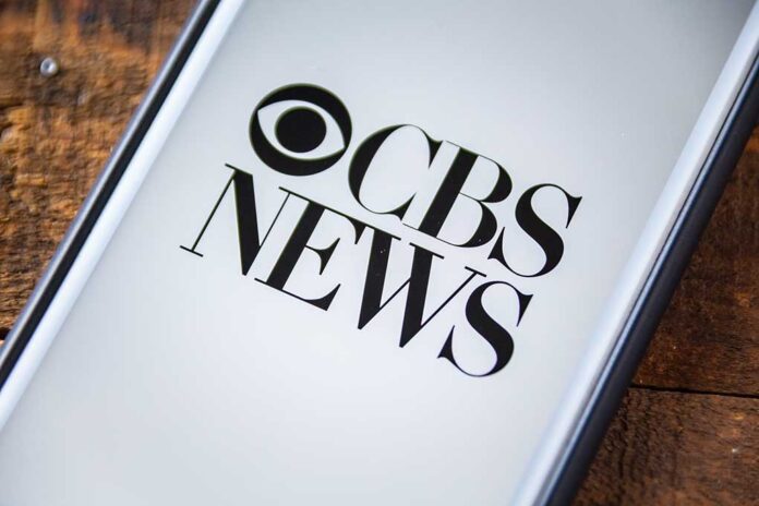 Phone screen showing CBS News logo.