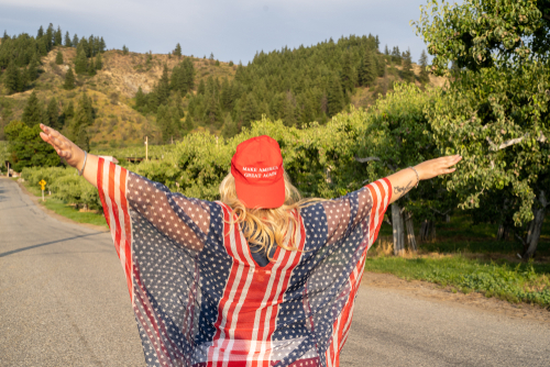 Person wearing Make America Great Again hat and American flag.