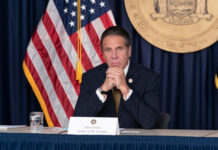 Governor Andrew Cuomo sitting at a conference table.