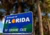 Welcome to Florida sign with palm trees background.